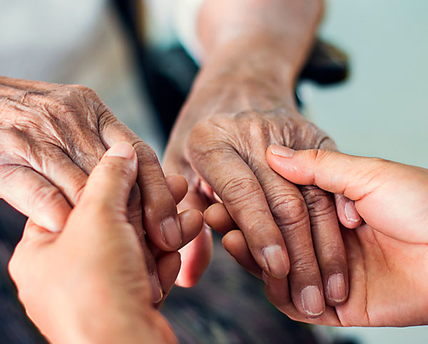 care-giver holding hands with another